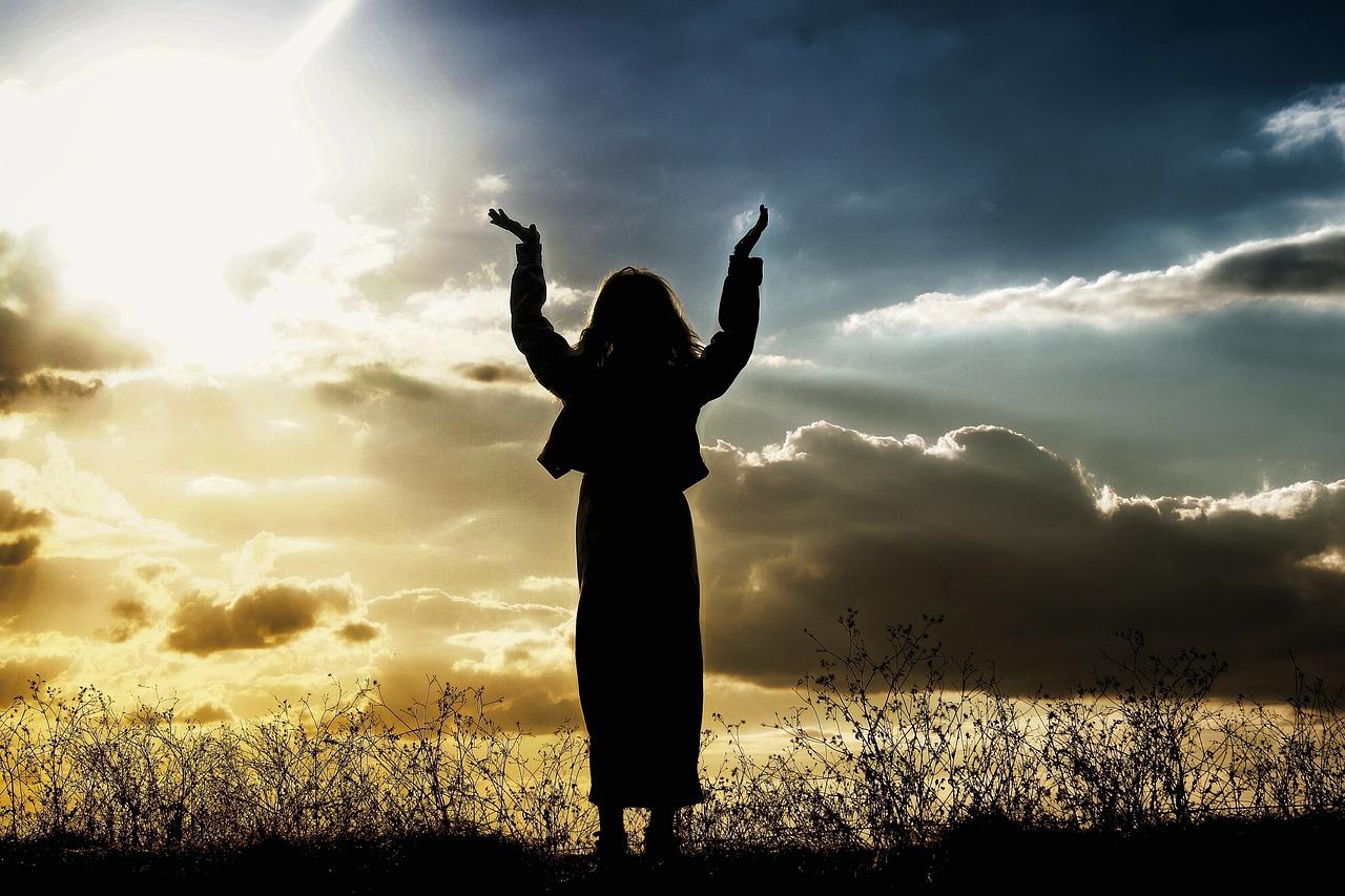 Woman lifting hands up praising and praying